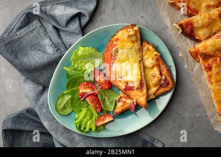 Panini cotti in forno con pomodoro, formaggio ed erbe su un piatto. Vista dall'alto. Foto Stock