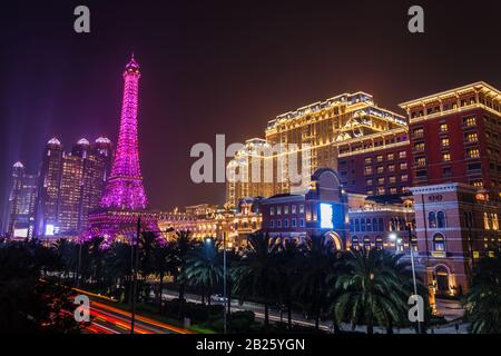 Strada con palme piene di luci al neon dei grattacieli di Macao e dei casinò di lusso, Macao Foto Stock