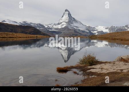 Il Cervino in autunno su moody giorno con la riflessione in StelliSee, Zermatt, Svizzera Foto Stock