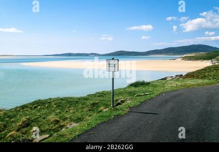 Strada costiera a circuito singolo con luogo di passaggio con le sabbie Luskentire (Losgaotir) oltre, Isle of Harris, Ebridi esterne, Scozia, Regno Unito Foto Stock