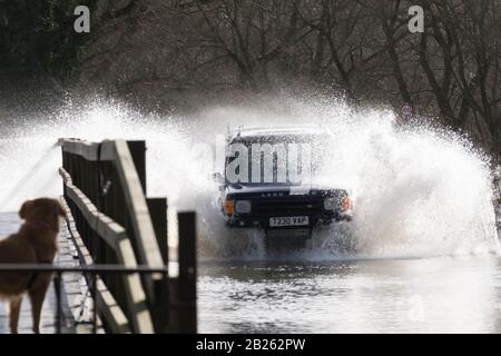 Lacock, Wiltshire, Regno Unito. 1st Mar, 2020. Il fiume Avon a Lacock ha fatto esplodere le sue rive e ha inondato la strada fuori dal villaggio. Segnaletica stradale chiusa sono sul posto, anche se alcuni conducenti sono ancora in corso attraverso l'acqua. Credit: Sig. Standfast/Alamy Live News Foto Stock