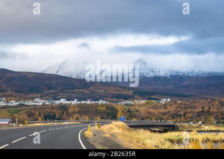 Akureyri più grande città del Nord in Islanda di fronte alle montagne innevate durante l'autunno Foto Stock
