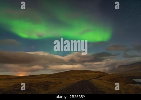 Aurora in Islanda luci settentrionali luminose travi che si innalzano in travi verdi sul paesaggio islandese Foto Stock