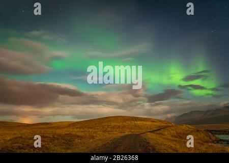 Aurora in Islanda luci settentrionali luminose travi che si innalza verde sul sentiero escursionistico Foto Stock