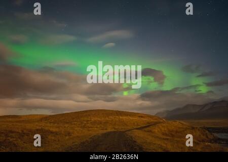 Aurora in Islanda luci settentrionali fasci luminosi sopra percorso escursionistico Foto Stock