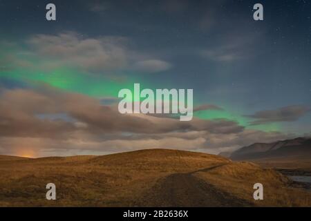 Aurora in Islanda luci settentrionali che splendono verde sul sentiero escursionistico in Islanda Foto Stock