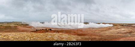 Geo attività di sorgente termale calda in Islanda Gunnuhver Hot Springs nuvola di vapore durante il vento pesante Foto Stock