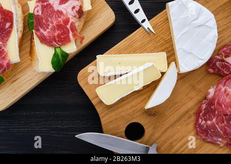 Vista aerea di camembert sandwich con pancetta affumicata su legno scuro tavolo. Foto Stock