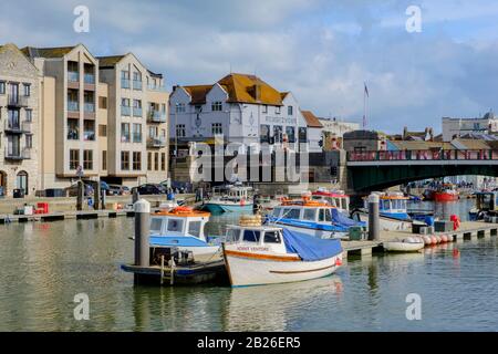 Barche ormeggiate sul porto di Weymouth con vista verso Town Bridge, Dorset, Sud Ovest Foto Stock