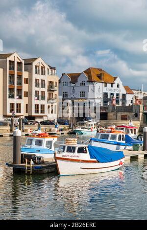 Barche ormeggiate sul porto di Weymouth con vista verso Town Bridge, Dorset, Sud Ovest Foto Stock