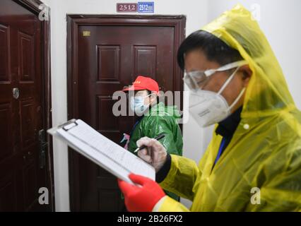 Pechino, La Provincia Cinese Di Hubei. 18th Feb, 2020. Il lavoratore della comunità con base a griglia li Wenli (L) bussa alla porta di un appartamento durante una campagna di screening sanitario presso la Comunità di Qingheju nel distretto di Qingshan di Wuhan, capitale della provincia Hubei della Cina centrale, 18 febbraio 2020. Credito: Cheng Min/Xinhua/Alamy Live News Foto Stock