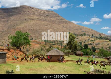 Uomini che arrivano a cavallo ad una cerimonia di iniziazione vicino a Pitseng (Leribe), Lesotho Foto Stock