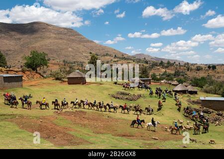 Uomini che arrivano a cavallo ad una cerimonia di iniziazione vicino a Pitseng (Leribe), Lesotho Foto Stock