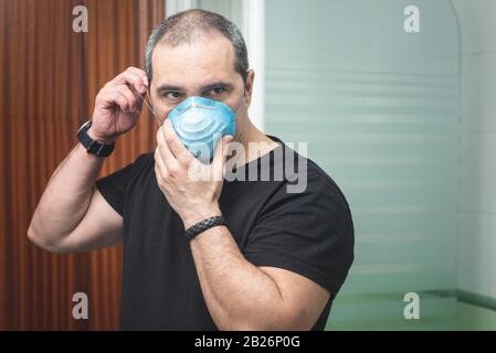 Ritratto di un uomo mettere una maschera protettiva per evitare la diffusione del concetto di virus con spazio di copia per il testo Foto Stock