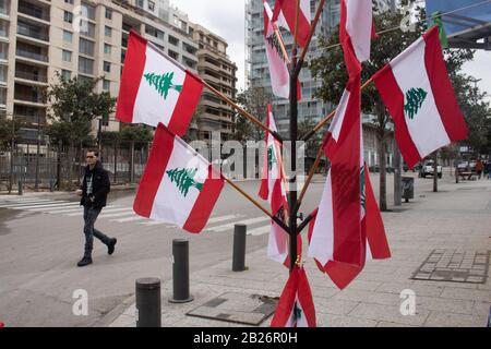 Beirut, Libano. 1 marzo 2020: Un pedone passa davanti alle bandiere libanesi sulle vendite nella Piazza dei Martiri Beirut, venduta ai manifestanti anti del governo anti che si battono contro la corruzione e migliori standard di vita. Credit: Amer ghazzal/Alamy Live News . Credit: Amer ghazzal/Alamy Live News Foto Stock