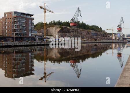 Vista sul fiume Aura e sulle gru portuali del parco Maununtyttärenpuisto a Turku, Finlandia Foto Stock