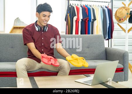 Giovane uomo asiatico online mercantili di moda blogger utilizzando  computer portatile per registrare video vlog dal vivo per revisione abbigliamento  casual. Influencer Online Foto stock - Alamy
