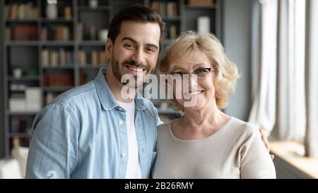 Ritratto di madre matura felice e canzone adulta abbracciando Foto Stock