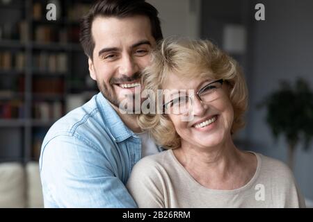 Ritratto di mamma felice senior e figlio adulto che abbracciano Foto Stock