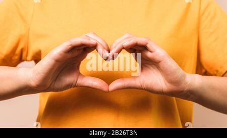 mani di closeup della donna in forma di cuore. amore di sé e prosperità Foto Stock