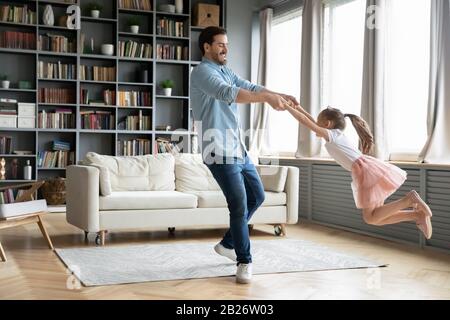 Giovane padre che balla con la figlia felice preschooler Foto Stock