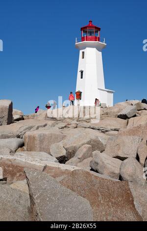 Peggy's Cove, Nuova Scozia, tranquillo faro sulle rocce con turisti a piedi sulla riva Foto Stock