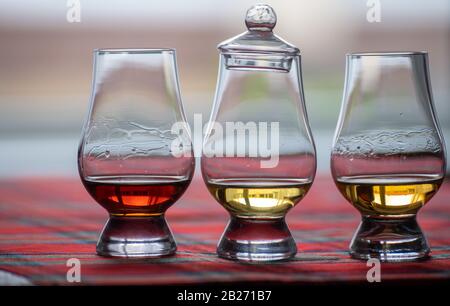 Bicchieri speciali a tulipano con coperchio per la degustazione di Scotch whisky in distilleria in Scozia, Regno Unito e tartan rosso Foto Stock