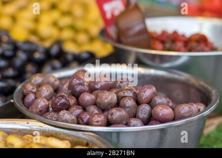 Un mucchio di olive marroni siriane lucide e piene di olio. All'interno di una ciotola di metallo. Stile arabo. Il Vecchio Mercato Di Mahane Yehuda, Gerusalemme. Foto Stock