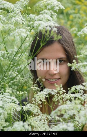 Verticale. Ragazza tra fiori bianchi. Estate. Foto Stock