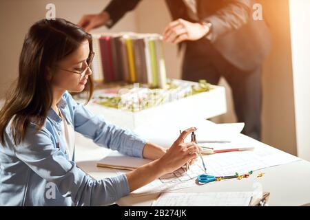 attraente architetto femminile godendo del suo lavoro, lavoro di squadra, primo piano vista laterale foto Foto Stock