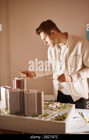 occhiali da uomo e un righello e la misurazione miniatura di costruzione, primo piano vista laterale foto. verticale colpo Foto Stock