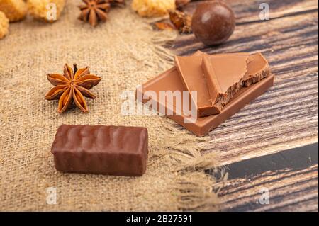 Cioccolato e anice stellato su uno sfondo di tessuto homeespun ruvido. Primo piano Foto Stock