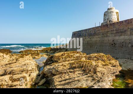 Spiaggia di Portreath e Harbour Arm a bassa marea - Portreath, Cornwall nord, Regno Unito. Foto Stock