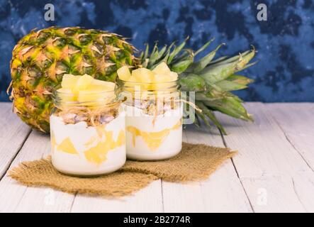 Due vasetti di yogurt all'ananas fatto in casa. Un concetto di dessert leggeri e sani. Foto Stock