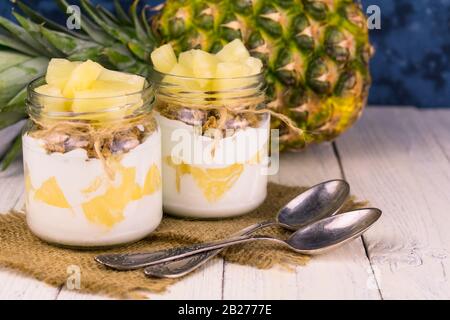 Due vasetti di yogurt all'ananas fatto in casa. Un concetto di dessert leggeri e sani. Foto Stock