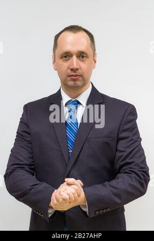 ritratto di un uomo d'affari sicuro, risoluto e di successo con un vestito grigio e cravatta blu Foto Stock