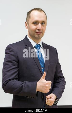 ritratto di un uomo d'affari sicuro, risoluto e di successo con un vestito grigio e cravatta blu Foto Stock