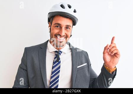 Giovane bel casco da uomo d'affari bici e cuffie wireless su sfondo isolato con un grande sorriso sul viso, che punta con la mano e il dito al Foto Stock