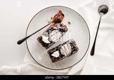 Due fette di torta al cioccolato Glassato su piastra bianca. Foto a soffitto, spazio di copia Foto Stock