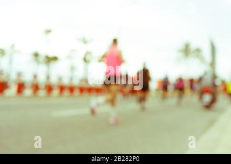 Immagine offuscata delle persone che corrono in una maratona massiccia in una giornata estiva soleggiata. Sano concetto di vita, allenamento e sport. Foto Stock