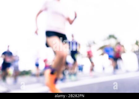Immagine offuscata delle persone che corrono in una maratona massiccia in una giornata estiva soleggiata. Sano concetto di vita, allenamento e sport. Foto Stock