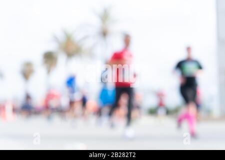 Immagine offuscata delle persone che corrono in una maratona massiccia in una giornata estiva soleggiata. Sano concetto di vita, allenamento e sport. Foto Stock