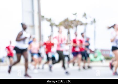 Immagine offuscata delle persone che corrono in una maratona massiccia in una giornata estiva soleggiata. Sano concetto di vita, allenamento e sport. Foto Stock
