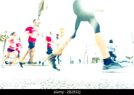 Immagine offuscata delle persone che corrono in una maratona massiccia in una giornata estiva soleggiata. Sano concetto di vita, allenamento e sport. Foto Stock