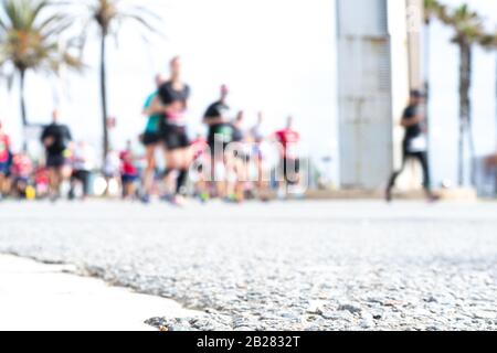 Immagine offuscata delle persone che corrono in una maratona massiccia in una giornata estiva soleggiata. Sano concetto di vita, allenamento e sport. Foto Stock