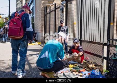 Vancouver - 05 MAGGIO 2019: Chinatown, Vancouver Canada. I senzatetto di Chinatown sulla strada durante un mercato delle pulci, Senza Tetto a piedi sulla strada. Foto Stock