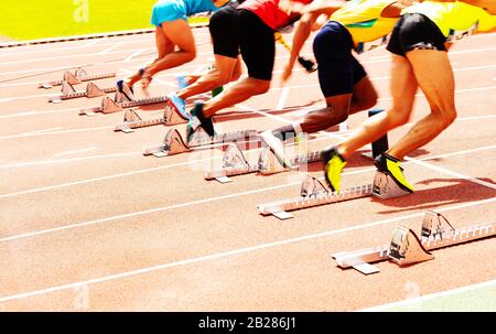 Primo piano di gruppo di uomini sportivi che iniziano a correre sprint vista dal retro Foto Stock