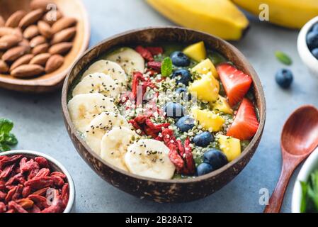Frullati superfood in ciotola di cocco con frutta e semi condimenti. Cibo sano, concetto di stile di vita sano Foto Stock
