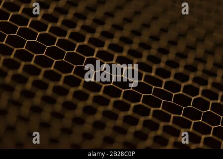 Foto ravvicinata ritagliata di piccoli fori di sfondo esagonali dorati Foto Stock