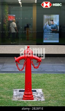 singapore, singapore - 2020.01.25: un vecchio / antico idrante fuoco su raffles place di fronte ad un ramo della banca hsbc Foto Stock